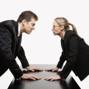 man and woman staring at each other with hostile expressions.